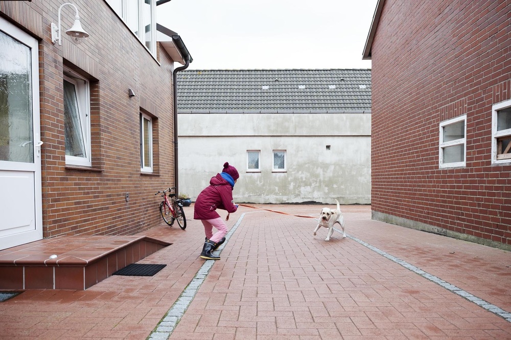 Fotografin Hamburg Reportage Portrait Reise Editorial Corporate Werbung Photography - After school, Kaya is greeted on her parent’s farm by their dog Nala