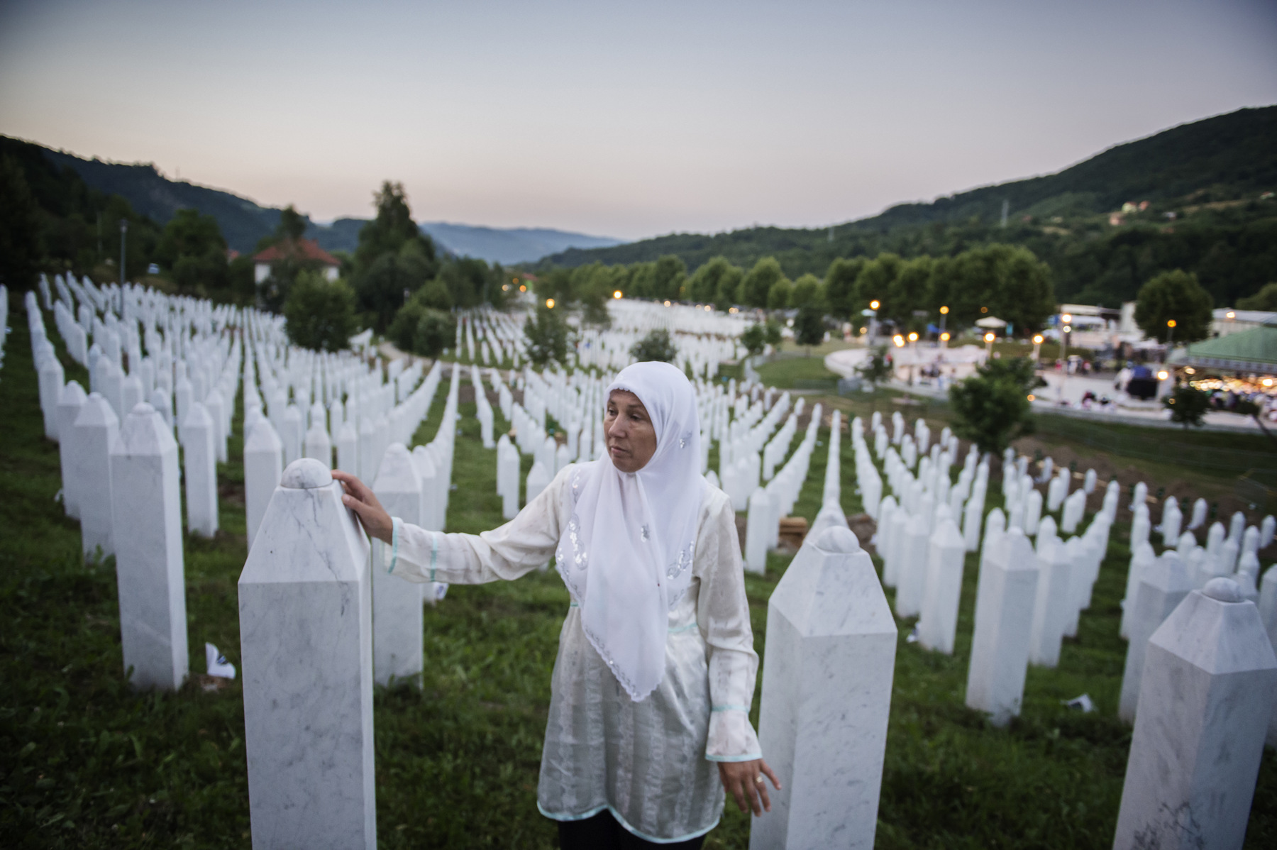 Photographer Anna Tärnhuvud - Hajreta lost her father, brother and husband in 1995. Shes standing at their graves at the Potocari burial site the night before the 20-year memorial day.