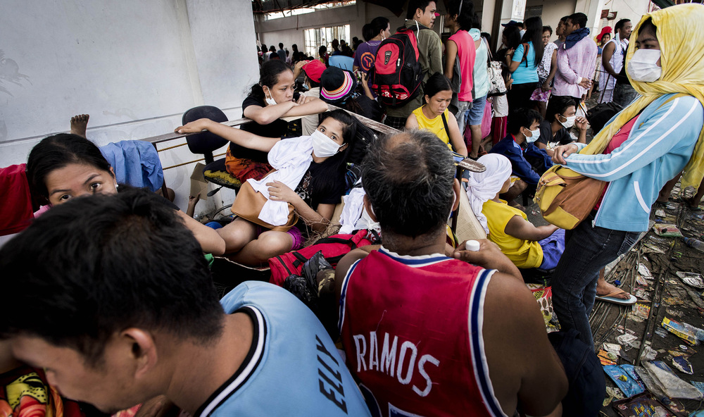 John T. Pedersen Photography - 2013 They survived People gather at Tacloban airport waiting for evacuation.