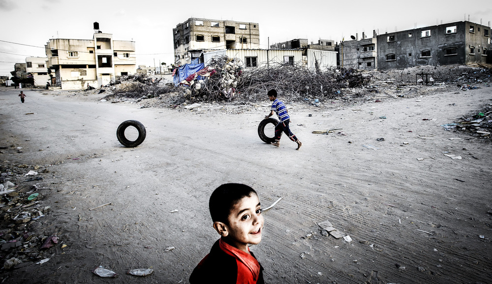 John T. Pedersen Photography - 2015 THE CHILDREN IN GAZA It is summer holiday in Gaza, but the residents have nowhere to go, since the strip is secluded from the rest of the world. The traumatized children play and run around in the ruins, and are afraid of more war. Unless the UN organization UNWRA receives additional funds for its general fund, they will be forced to keep schools closed from the fall. This will mean that Gazas 240,000 children do not have a school to attend. The people of Gaza are impatient. One year ago, the Gaza war started, in which 140,000 houses and apartments were completely or partially destroyed. Not one of the more than 12,000 completely destroyed houses has been rebuilt.