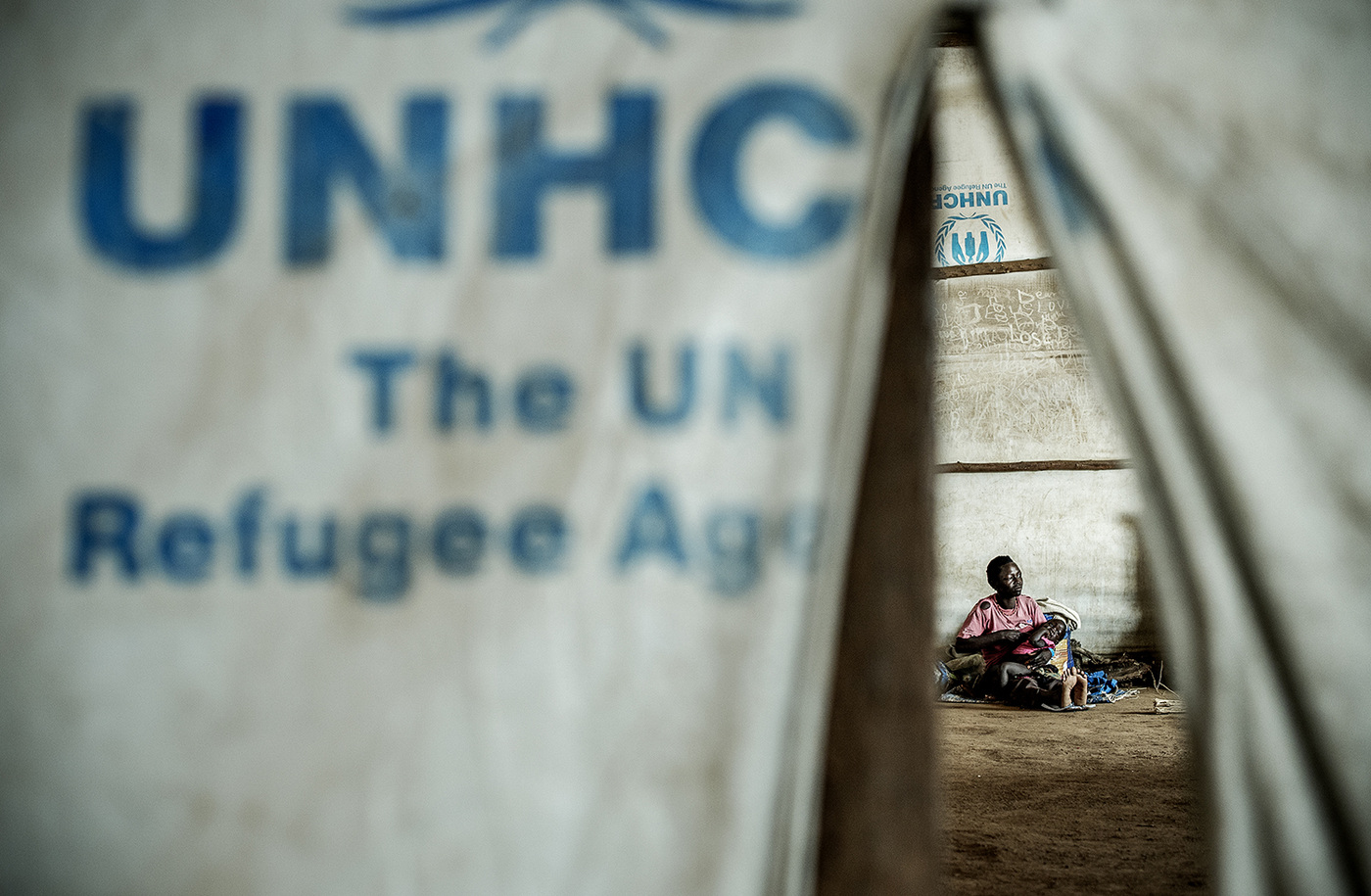 John T. Pedersen Photography - 2018 Last stop Uganda Jenneth (22) and her son Lemy (1) is getting on the bus, which will take them to a permanent settlement further into Uganda. Its just a few hours ago since they arrived at the Goboro collection center. They will soon be leaving together with other refugees. Strangers, but from the same country and with the same goal.