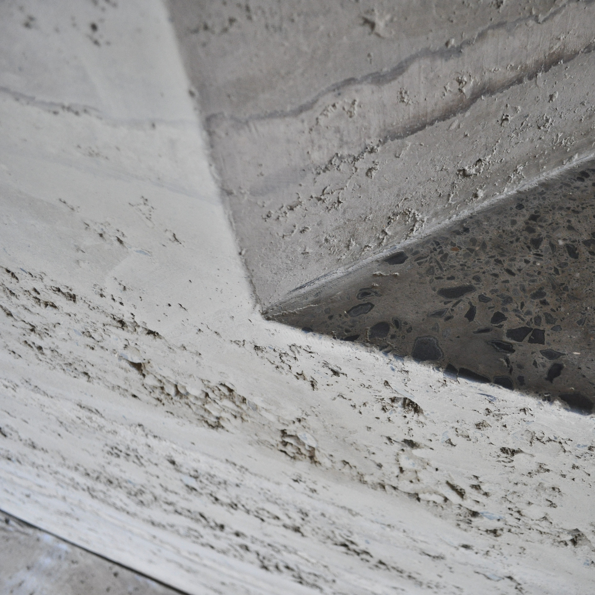 Un mur en pisé intérieur avec des ouvertures en biais et des spots — free download
